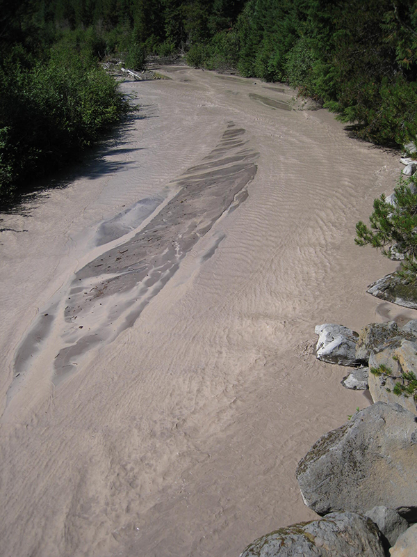An aerial view of a river full of brown water that is full of sediment.